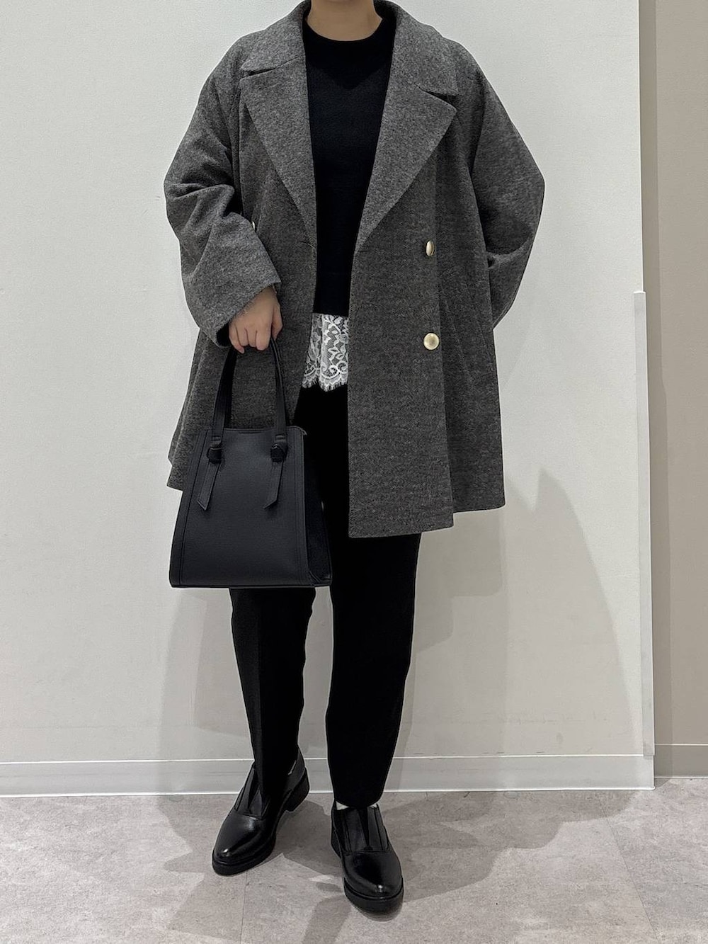ブラック系のショルダーバッグ、グレー系のチェスターコート、ブラック系のその他パンツを着用したレディースの冬コーディネートの4枚目の写真