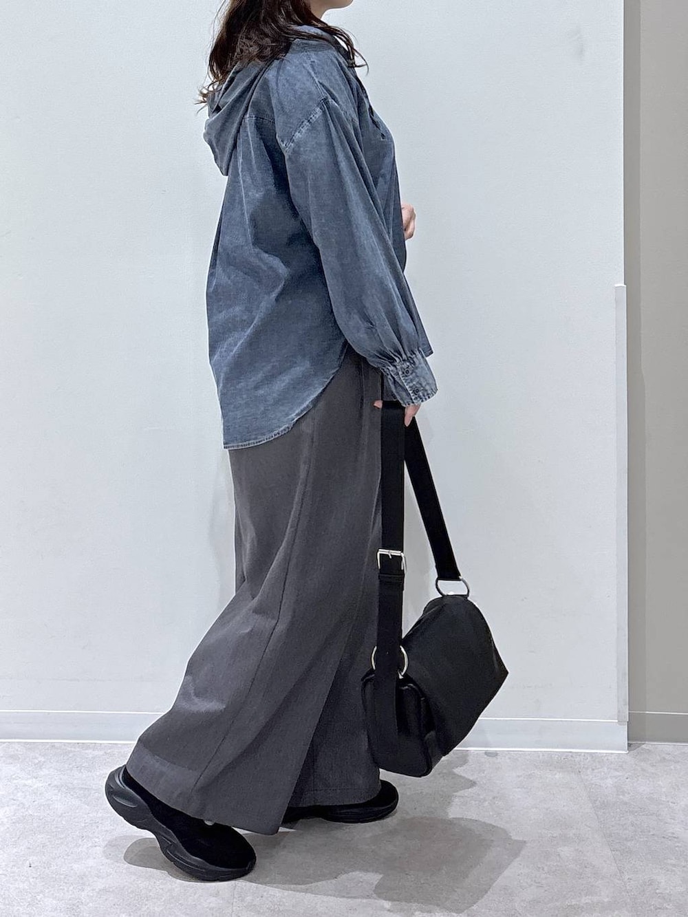 ブラック系のその他シューズ、ブルー系のシャツ/ブラウス、ブラック系のショルダーバッグを着用したレディースの秋コーディネートの2枚目の写真