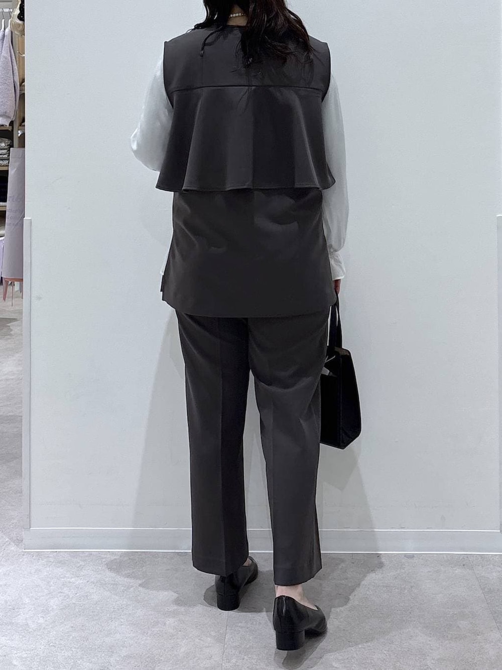 ブラック系のショルダーバッグ、ブラック系のパンプス、グレー系のセットアップを着用したレディースの冬コーディネートの3枚目の写真