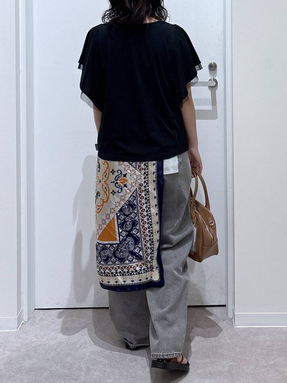 グレー系のデニムパンツ、ベージュ系のボストンバッグ、ブラック系のTシャツ/カットソーを着用したレディースの夏コーディネートの3枚目の写真