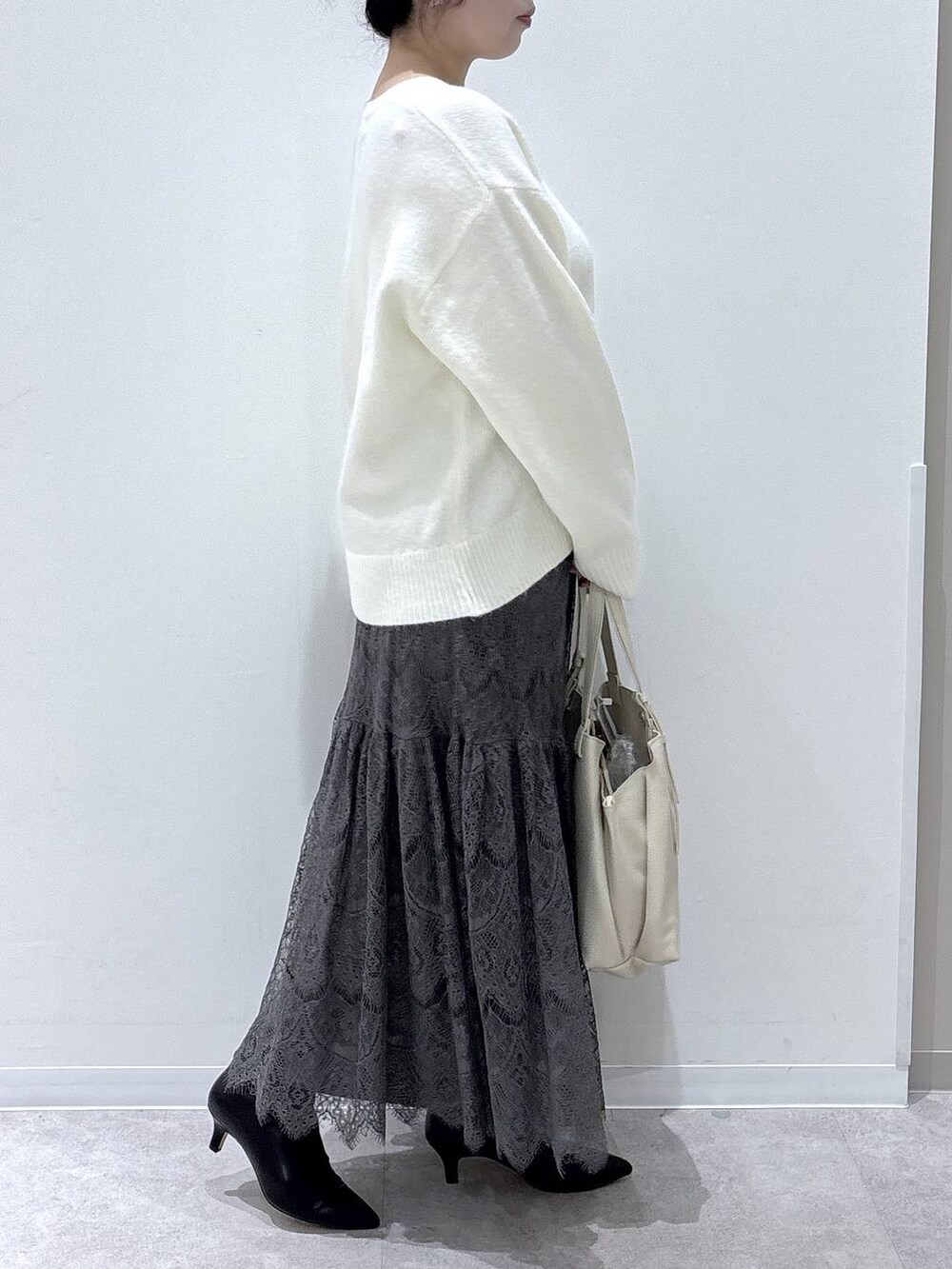 ホワイト系のショルダーバッグ、グレー系のブルゾン、グレー系のワンピースを着用したレディースの冬コーディネートの5枚目の写真