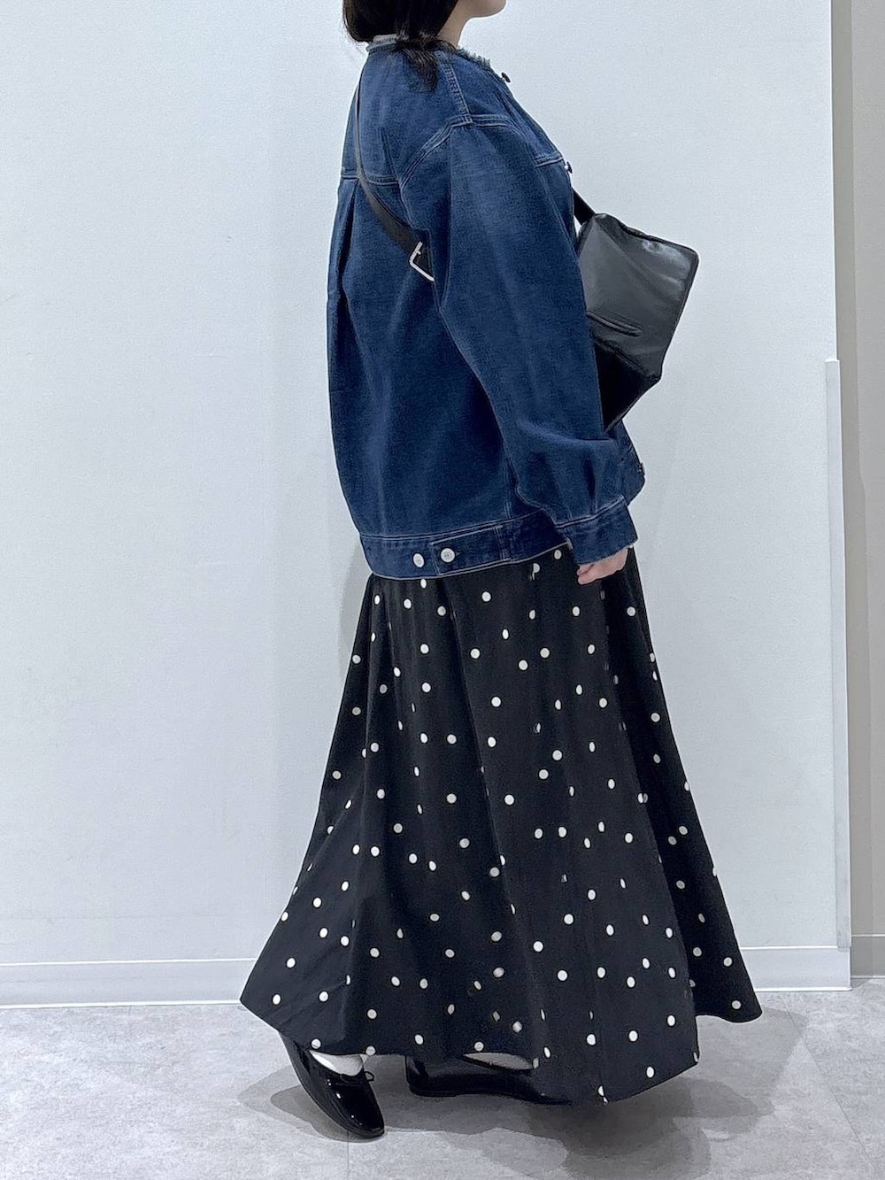 ブラック系のバレエシューズ、ブルー系のデニムジャケット、ホワイト系のニット/セーターを着用したレディースの冬コーディネートの2枚目の写真