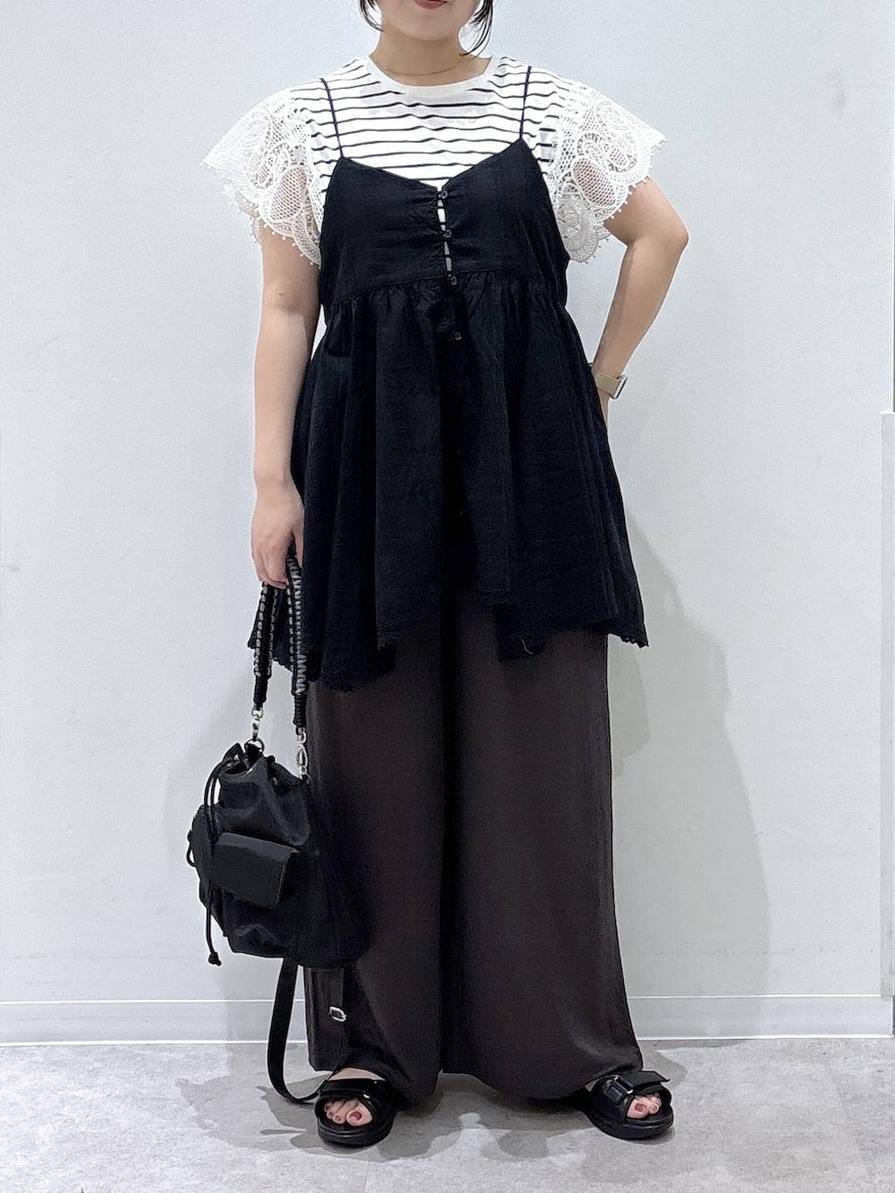 ブラック系のシャツ/ブラウス、ブラック系のサンダル、ホワイト系のTシャツ/カットソーを着用したレディースの夏コーディネートの4枚目の写真