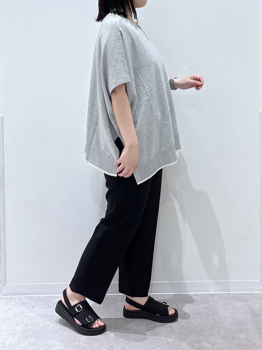 グレー系のニット/セーター、ブラック系のその他パンツ、ブラック系のサンダルを着用したレディースの春コーディネートの2枚目の写真
