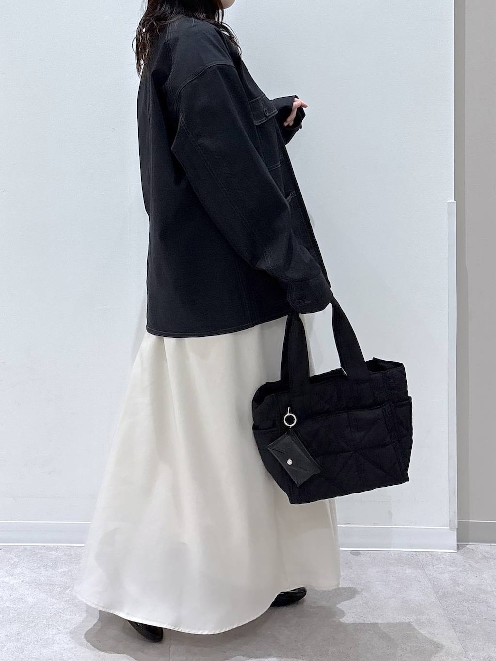 ブラック系のバレエシューズ、ブラック系のトートバッグ、ベージュ系のスカートを着用したレディースの春コーディネートの2枚目の写真