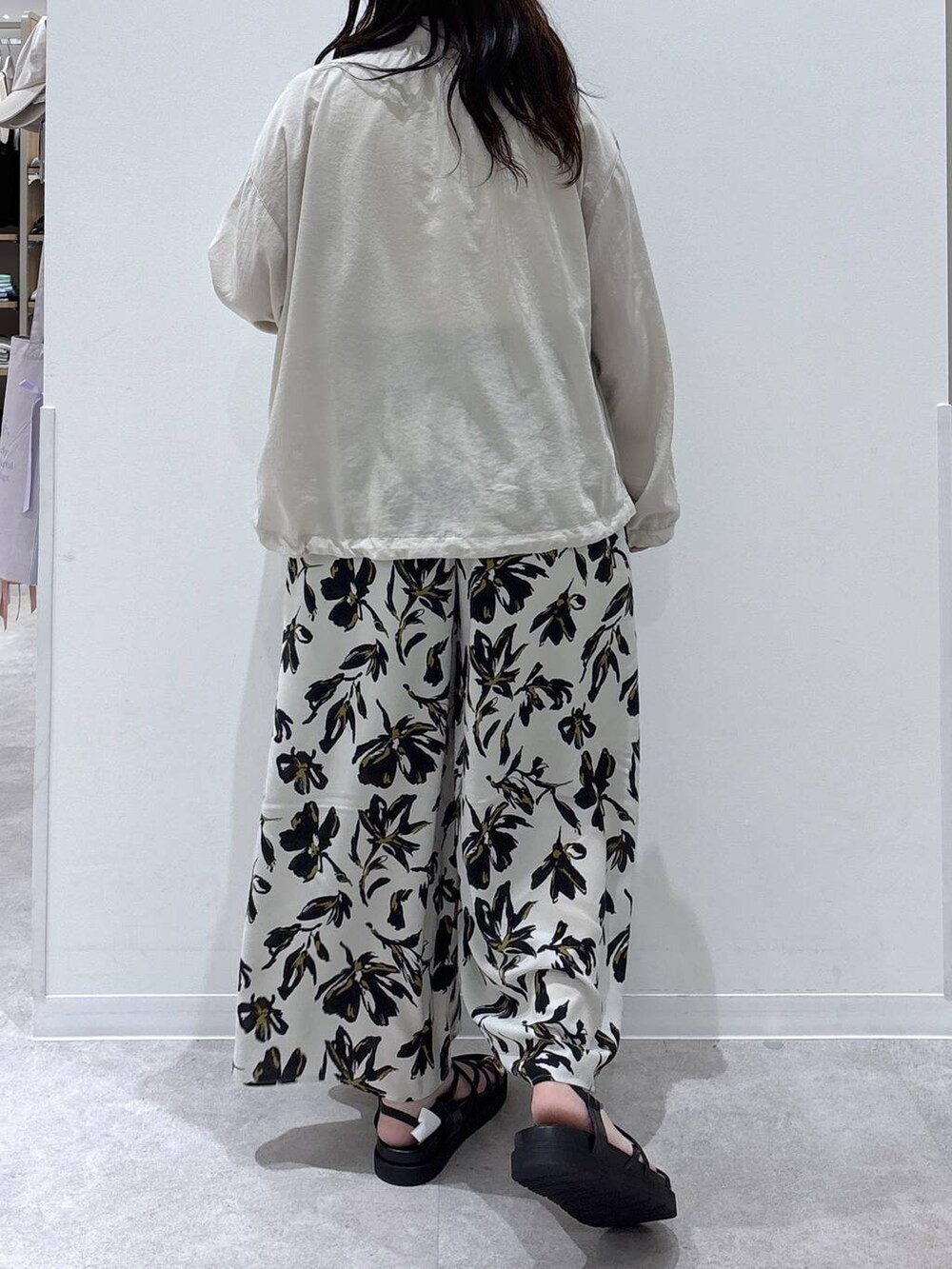 ベージュ系のブルゾン、ホワイト系のタンクトップ、ホワイト系のその他パンツを着用したレディースの夏コーディネートの3枚目の写真