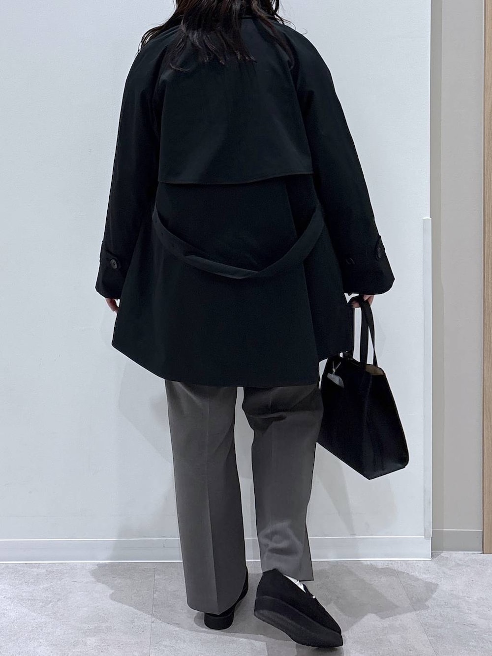 ブラック系のローファー、ブラック系のショルダーバッグ、ブルー系のトレンチコートを着用したレディースの春コーディネートの3枚目の写真