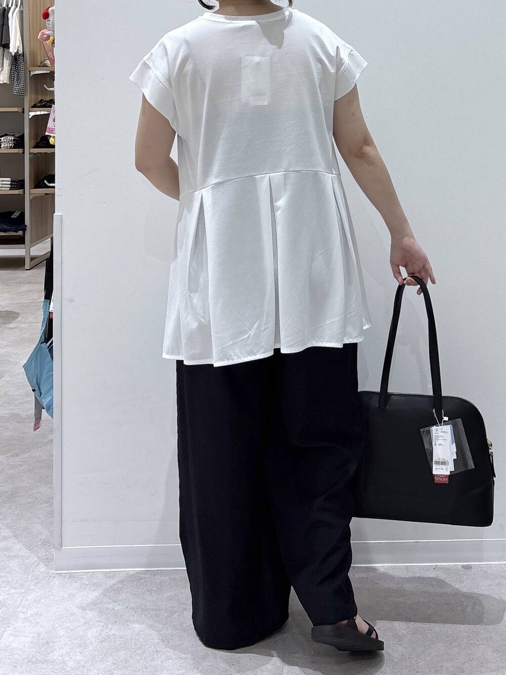 ブラック系のボストンバッグ、ブラック系のその他パンツ、ホワイト系のTシャツ/カットソーを着用したレディースの夏コーディネートの3枚目の写真