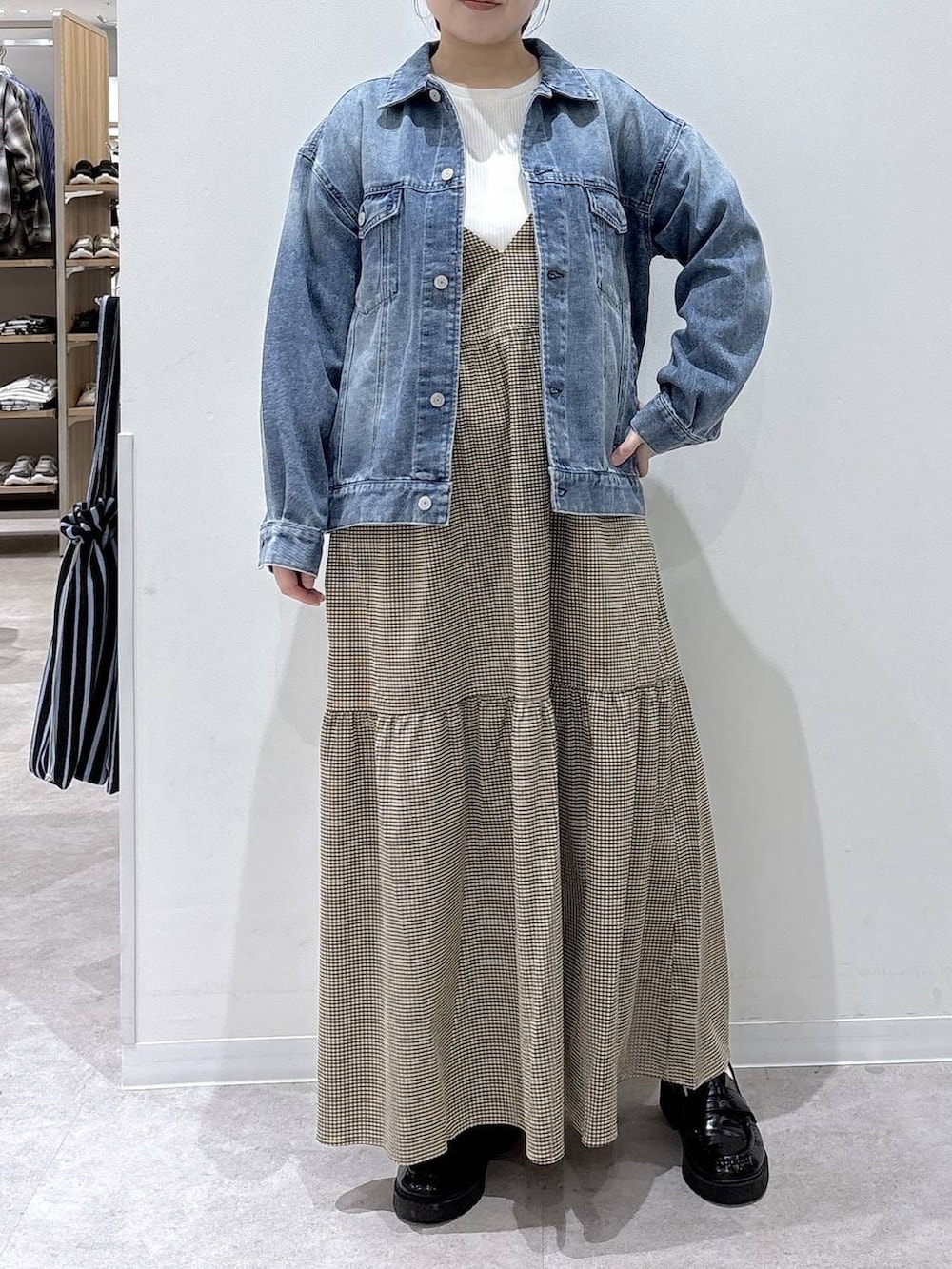 ブルー系のデニムジャケット、イエロー系のワンピースを着用したレディースの春コーディネートの4枚目の写真