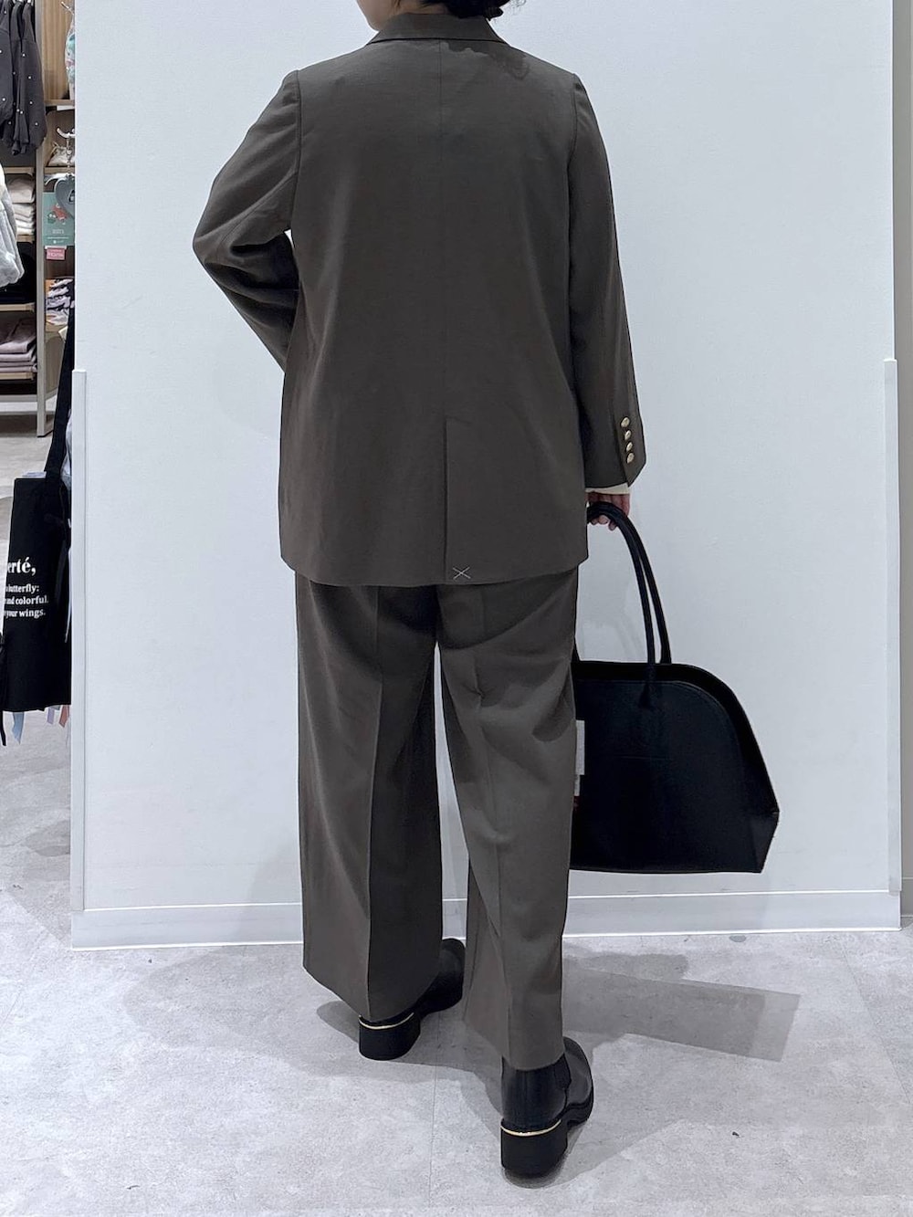 ブラック系のトートバッグ、ベージュ系のテーラードジャケット、ベージュ系のその他パンツを着用したレディースの秋コーディネートの3枚目の写真