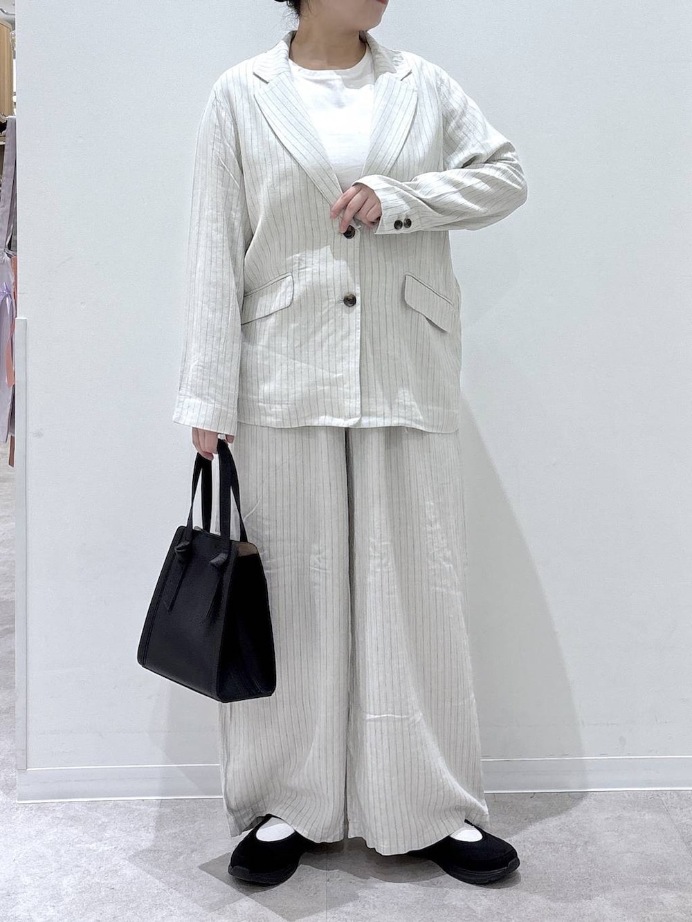 ブラック系のショルダーバッグ、ベージュ系のその他パンツ、ブラック系のスニーカーを着用したレディースの春コーディネートの3枚目の写真