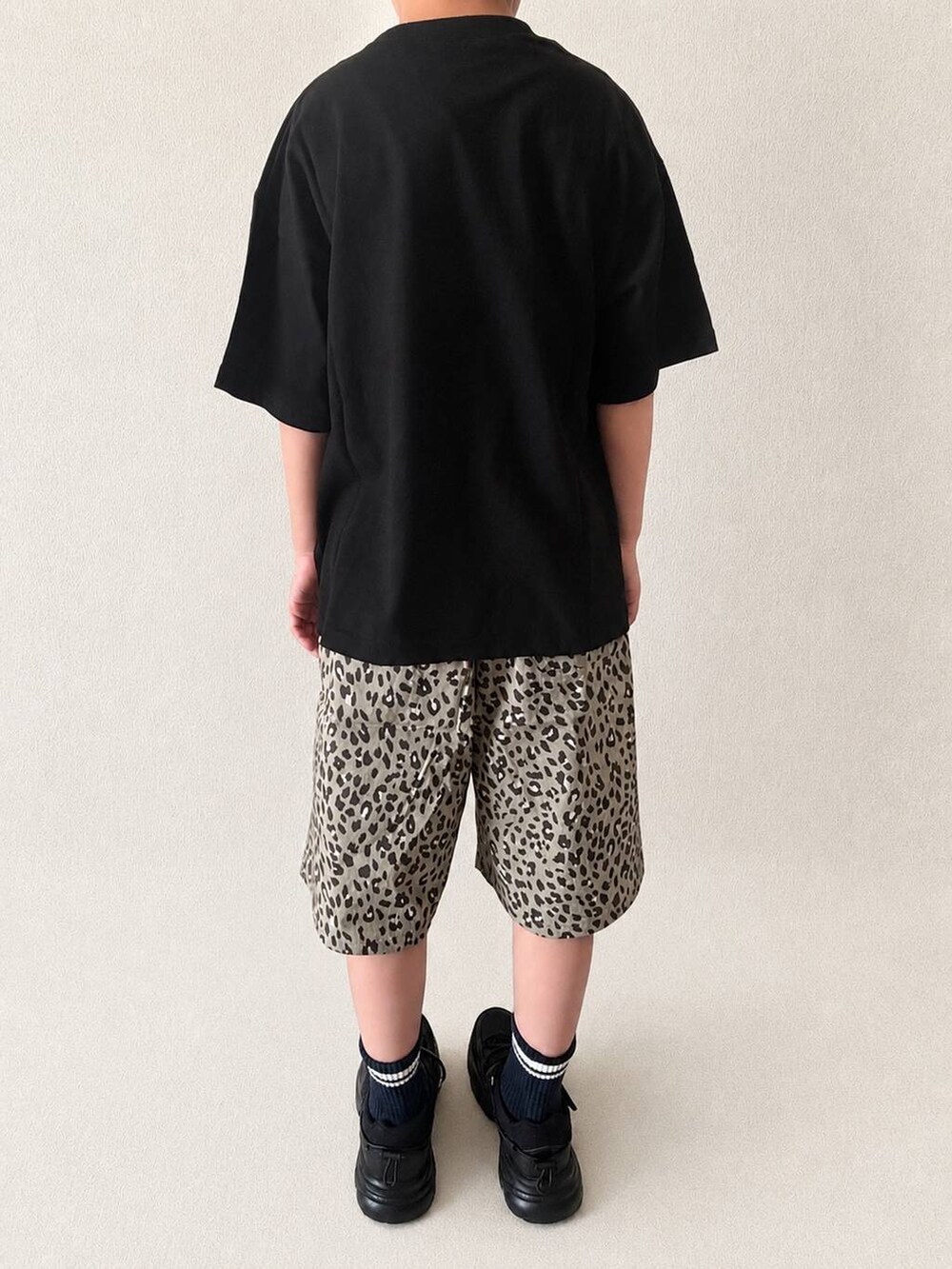 ブラウン系のその他パンツ、ブラック系のスニーカー、ブラック系のTシャツ/カットソーを着用したキッズの春コーディネートの2枚目の写真