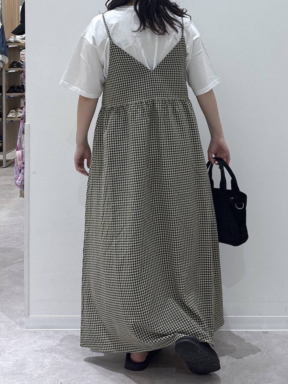 ブラック系のトートバッグ、ホワイト系のTシャツ/カットソー、ブラック系のサンダルを着用したレディースの夏コーディネートの3枚目の写真