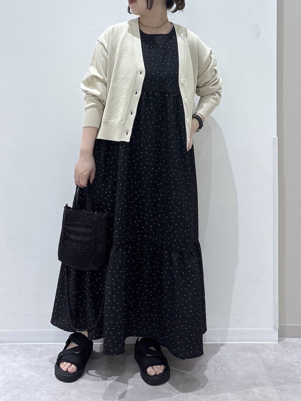 ベージュ系のカーディガン/ボレロ、ブラック系のワンピース、ブラック系のサンダルを着用したレディースの春コーディネートの4枚目の写真