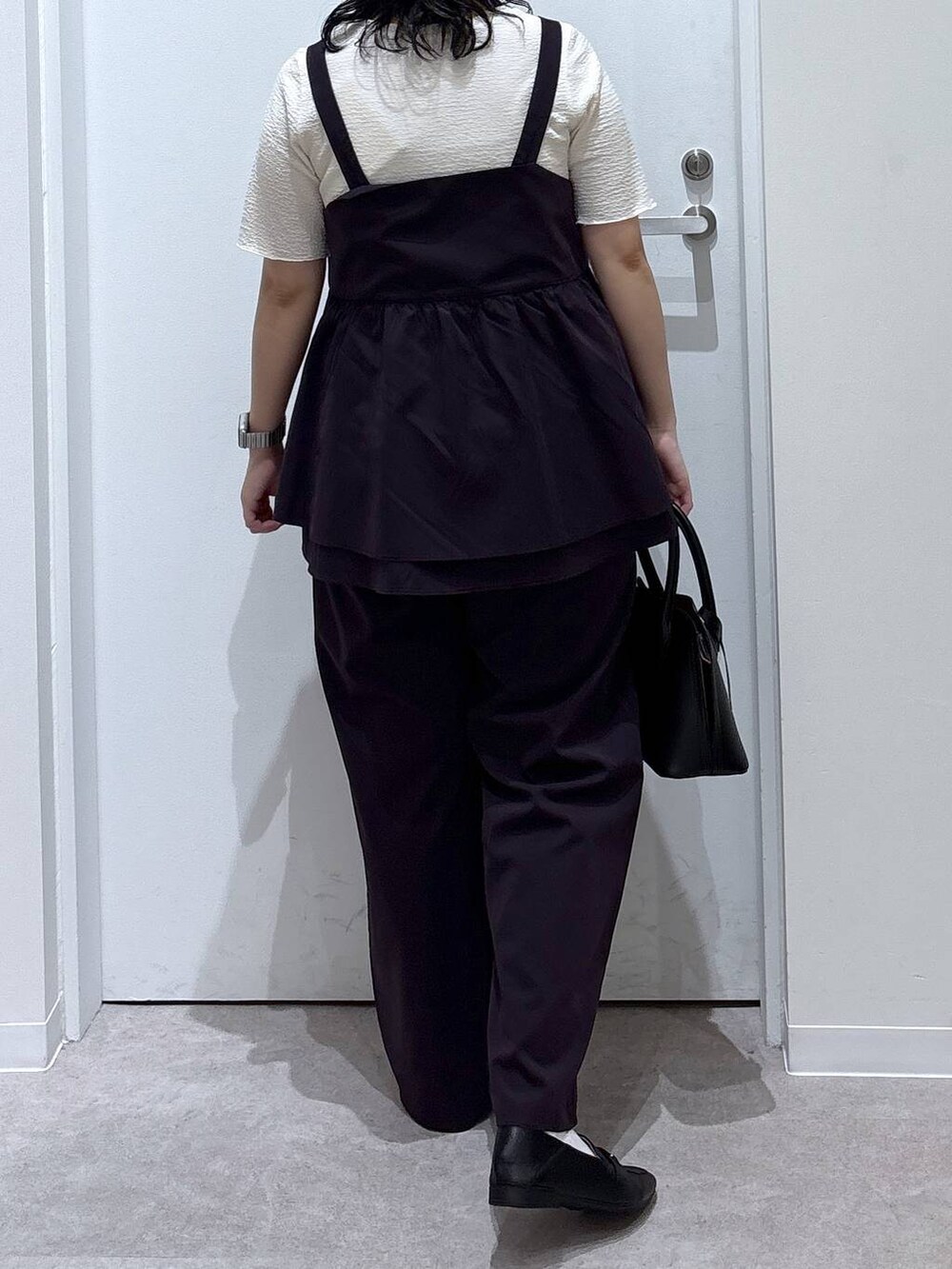 ブラック系のローファー、ブラック系のショルダーバッグ、ホワイト系のTシャツ/カットソーを着用したレディースの夏コーディネートの3枚目の写真