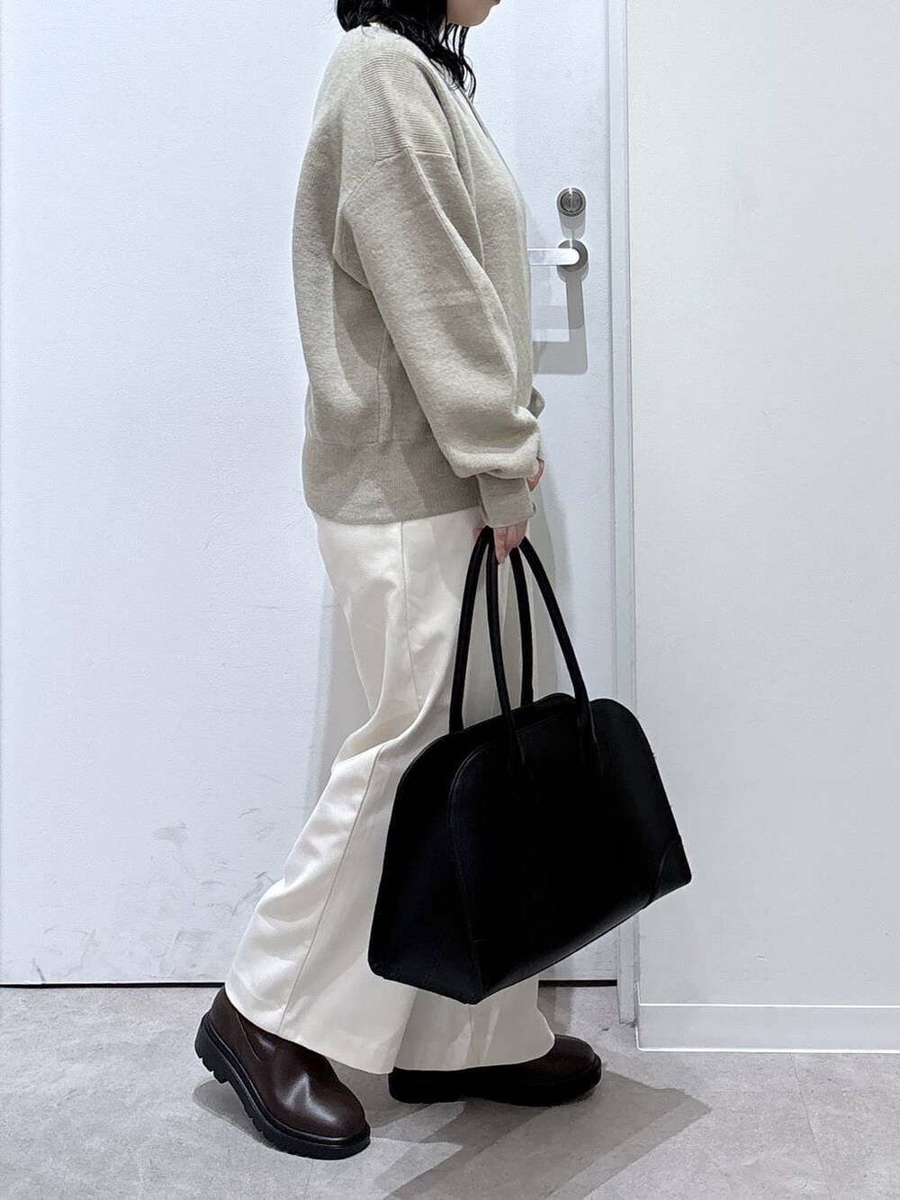 ブラック系のトートバッグ、ブラウン系のブーツ、グレー系のその他パンツを着用したレディースの冬コーディネートの2枚目の写真