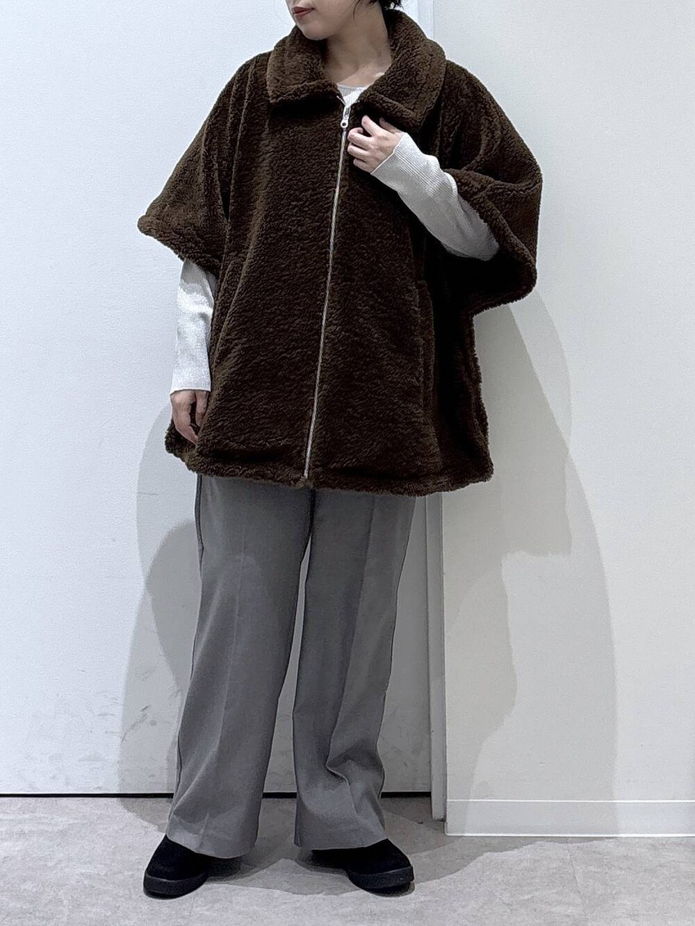 ベージュ系のニット/セーター、グレー系のその他パンツ、ブラウン系のポンチョを着用したレディースの秋コーディネートの4枚目の写真