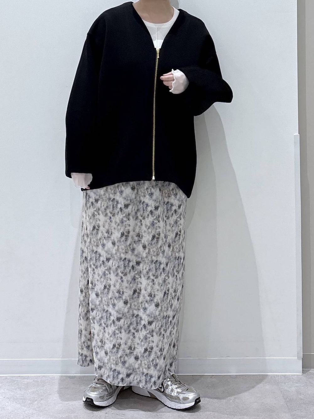 ブラック系のブルゾン、ホワイト系のTシャツ/カットソー、ベージュ系のスカートを着用したレディースの冬コーディネートの4枚目の写真