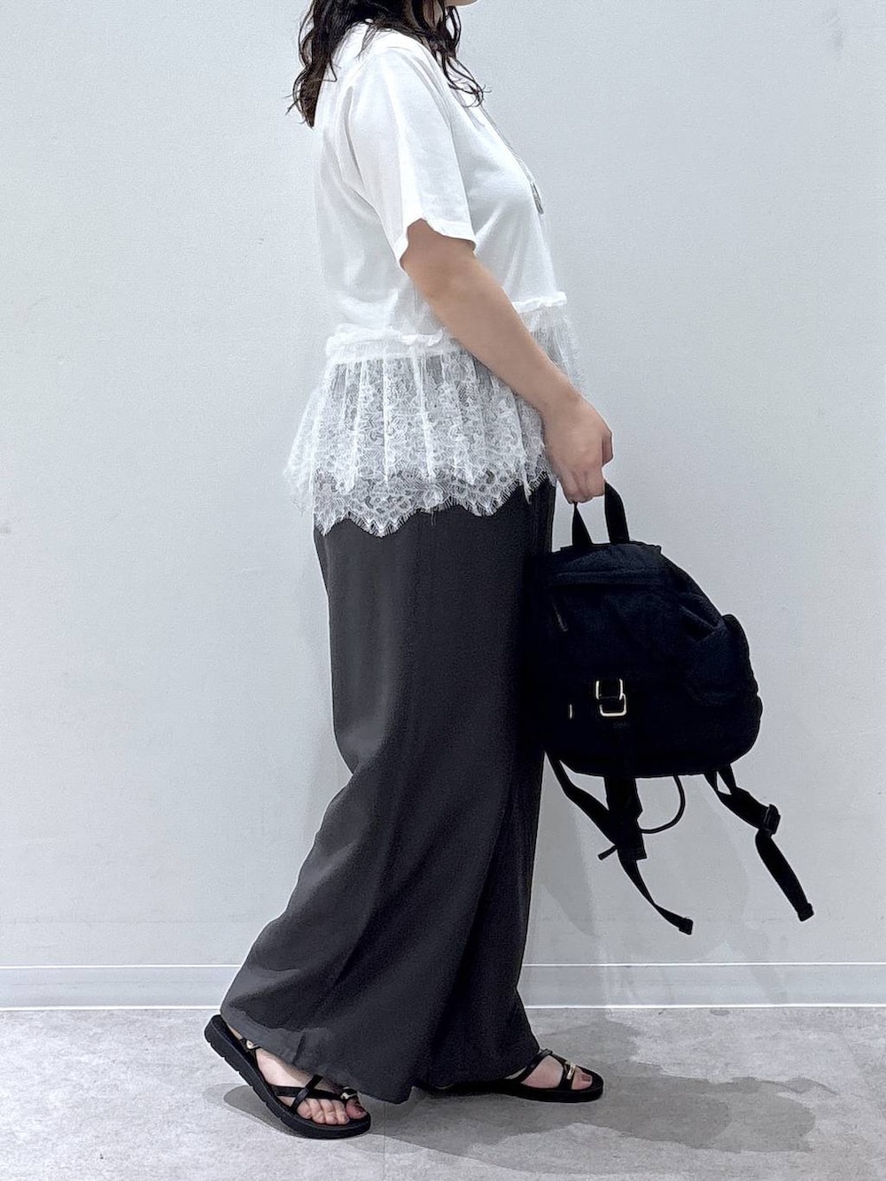 ブラウン系のその他パンツ、ブラック系のサンダル、ホワイト系のTシャツ/カットソーを着用したレディースの夏コーディネートの2枚目の写真
