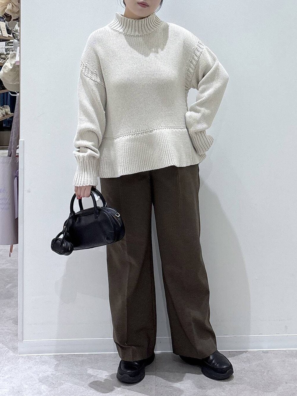 ブラウン系のその他パンツ、ブラック系のブーツ、ブラック系のハンドバッグを着用したレディースの冬コーディネートの3枚目の写真