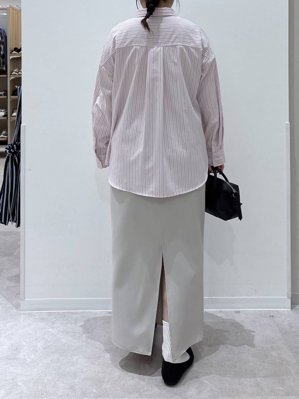 ブラック系のパンプス、ピンク系のシャツ/ブラウス、グレー系のスカートを着用したレディースの春コーディネートの3枚目の写真