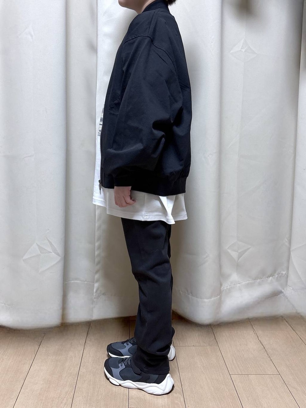 ブラック系のデニムパンツ、ブラック系のスニーカー、ブラック系のMA-1を着用したキッズの冬コーディネートの2枚目の写真