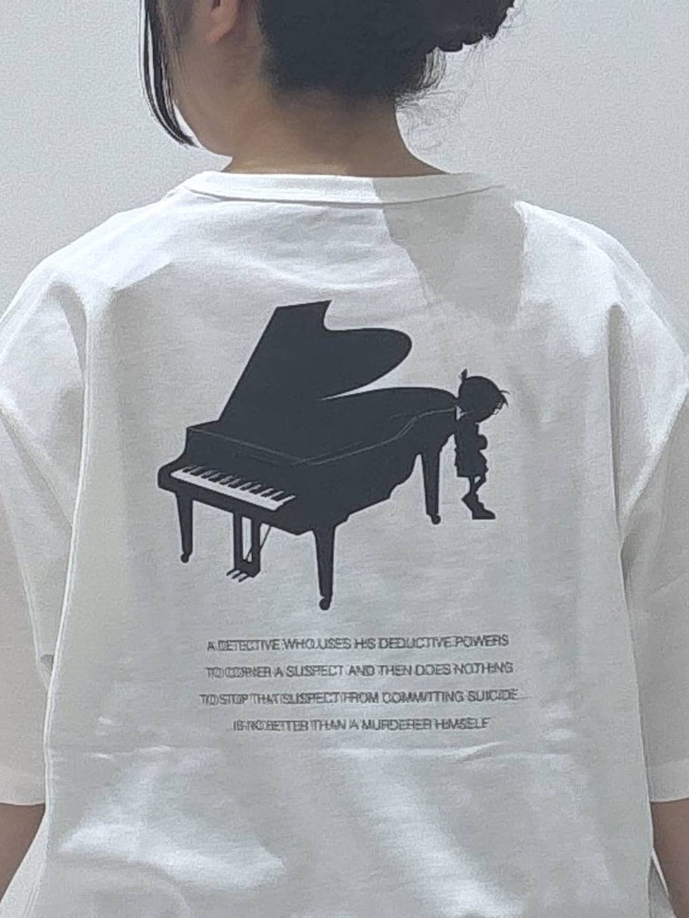 ブラック系のスカート、ブラック系のショルダーバッグ、ホワイト系のTシャツ/カットソーを着用したレディースの春コーディネートの3枚目の写真