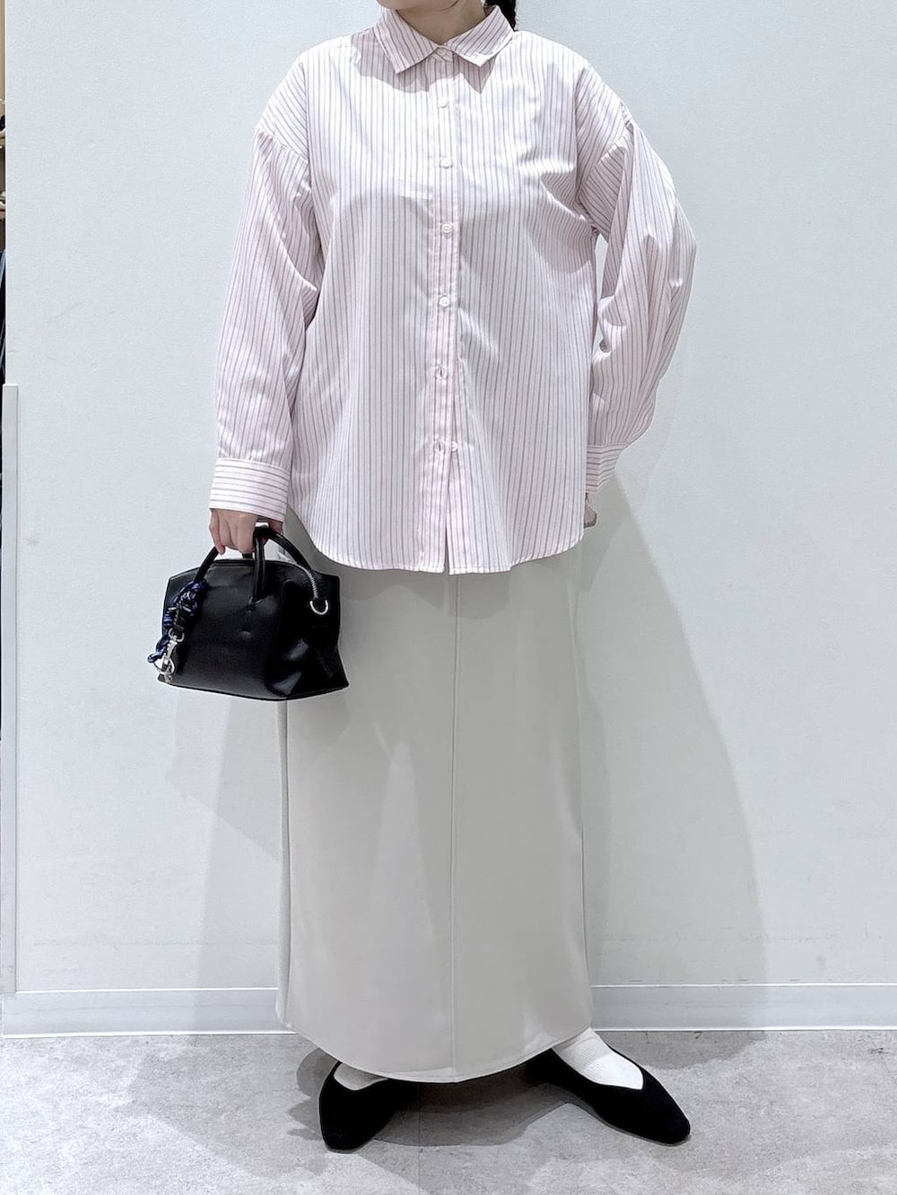 ブラック系のパンプス、ピンク系のシャツ/ブラウス、グレー系のスカートを着用したレディースの春コーディネートの4枚目の写真