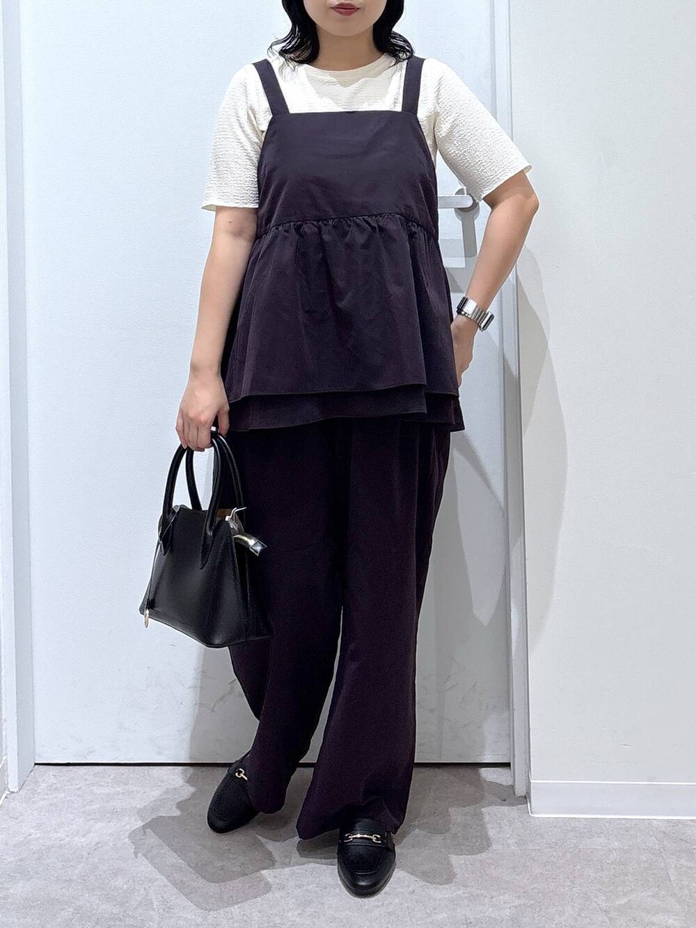 ブラック系のローファー、ブラック系のショルダーバッグ、ホワイト系のTシャツ/カットソーを着用したレディースの夏コーディネートの5枚目の写真