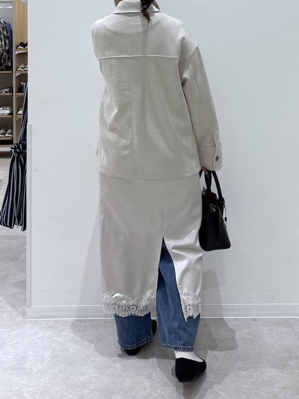 ブラック系のパンプス、ブラック系のショルダーバッグ、ベージュ系のテーラードジャケットを着用したレディースの春コーディネートの3枚目の写真