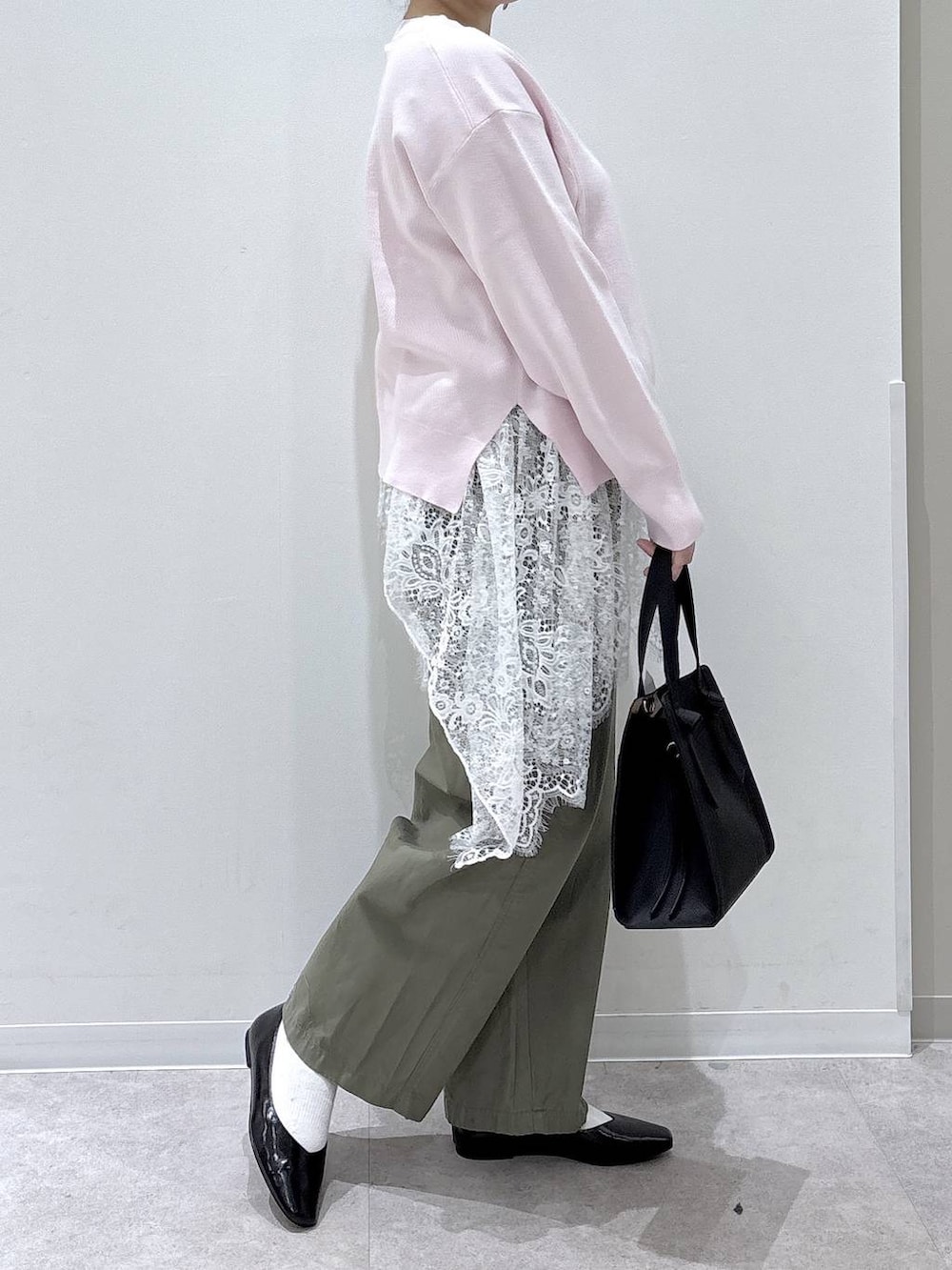 ブラック系のパンプス、ブラック系のショルダーバッグ、ホワイト系のその他トップスを着用したレディースの春コーディネートの2枚目の写真