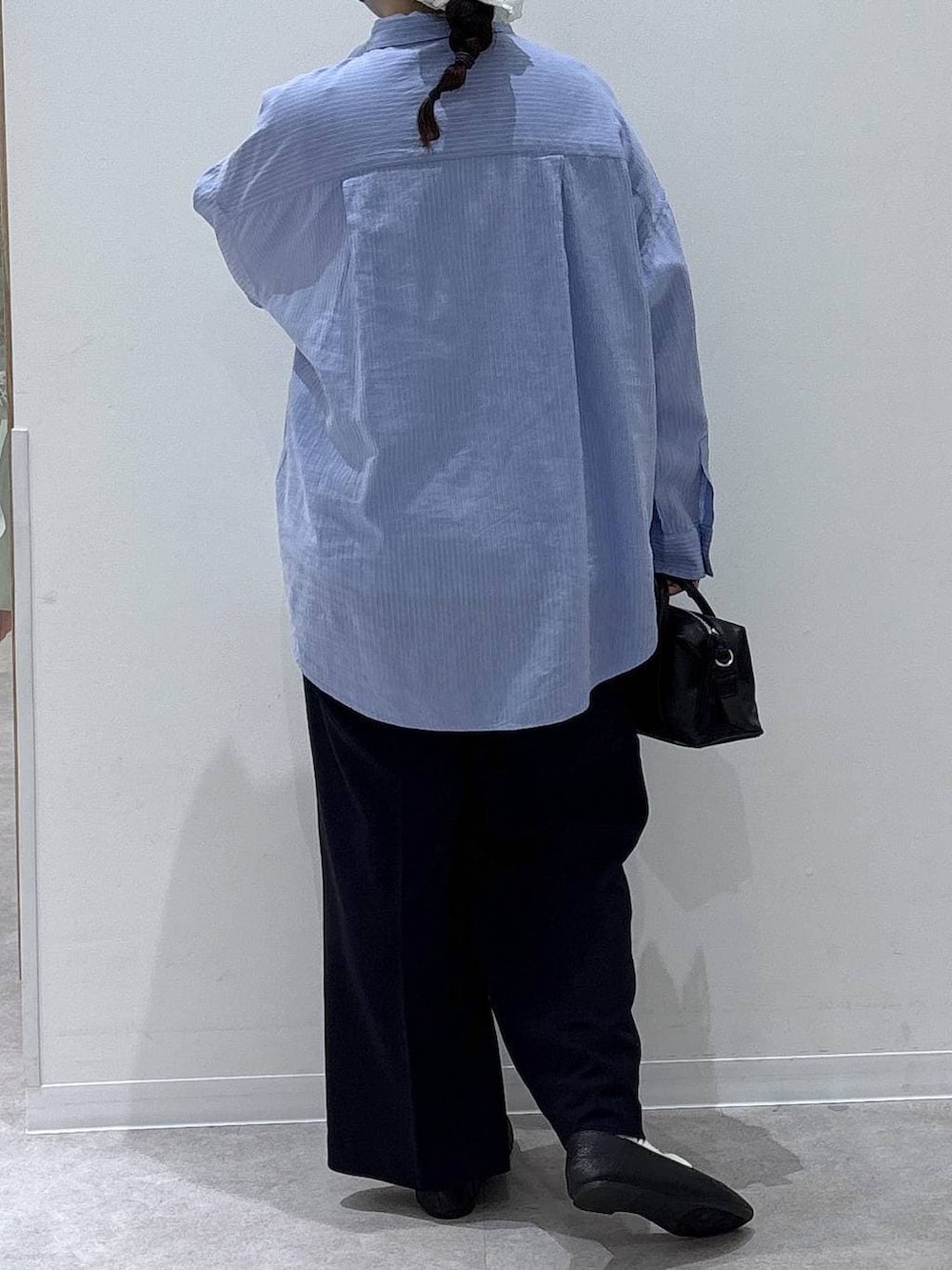 ブラック系のその他シューズ、ブラック系のボストンバッグ、ブルー系のシャツ/ブラウスを着用したレディースの春コーディネートの3枚目の写真