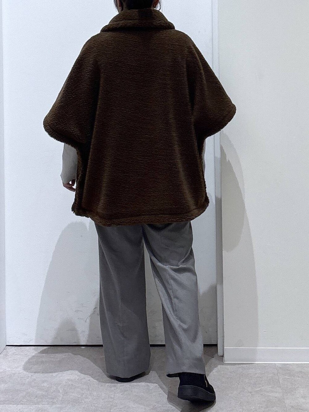 ベージュ系のニット/セーター、グレー系のその他パンツ、ブラウン系のポンチョを着用したレディースの秋コーディネートの3枚目の写真