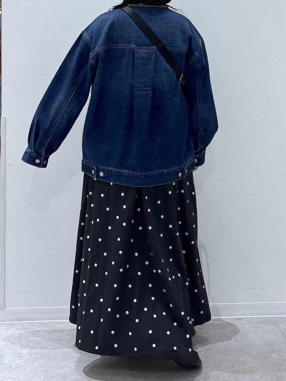 ブラック系のバレエシューズ、ブルー系のデニムジャケット、ホワイト系のニット/セーターを着用したレディースの冬コーディネートの3枚目の写真