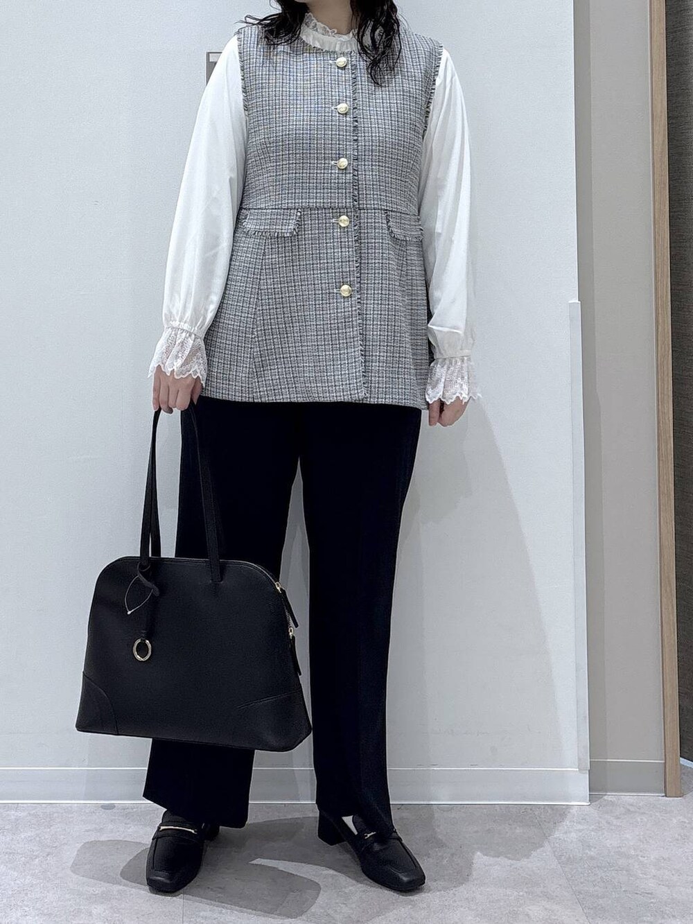 ブラック系のローファー、ホワイト系のシャツ/ブラウス、ブルー系のスラックスを着用したレディースの冬コーディネートの3枚目の写真