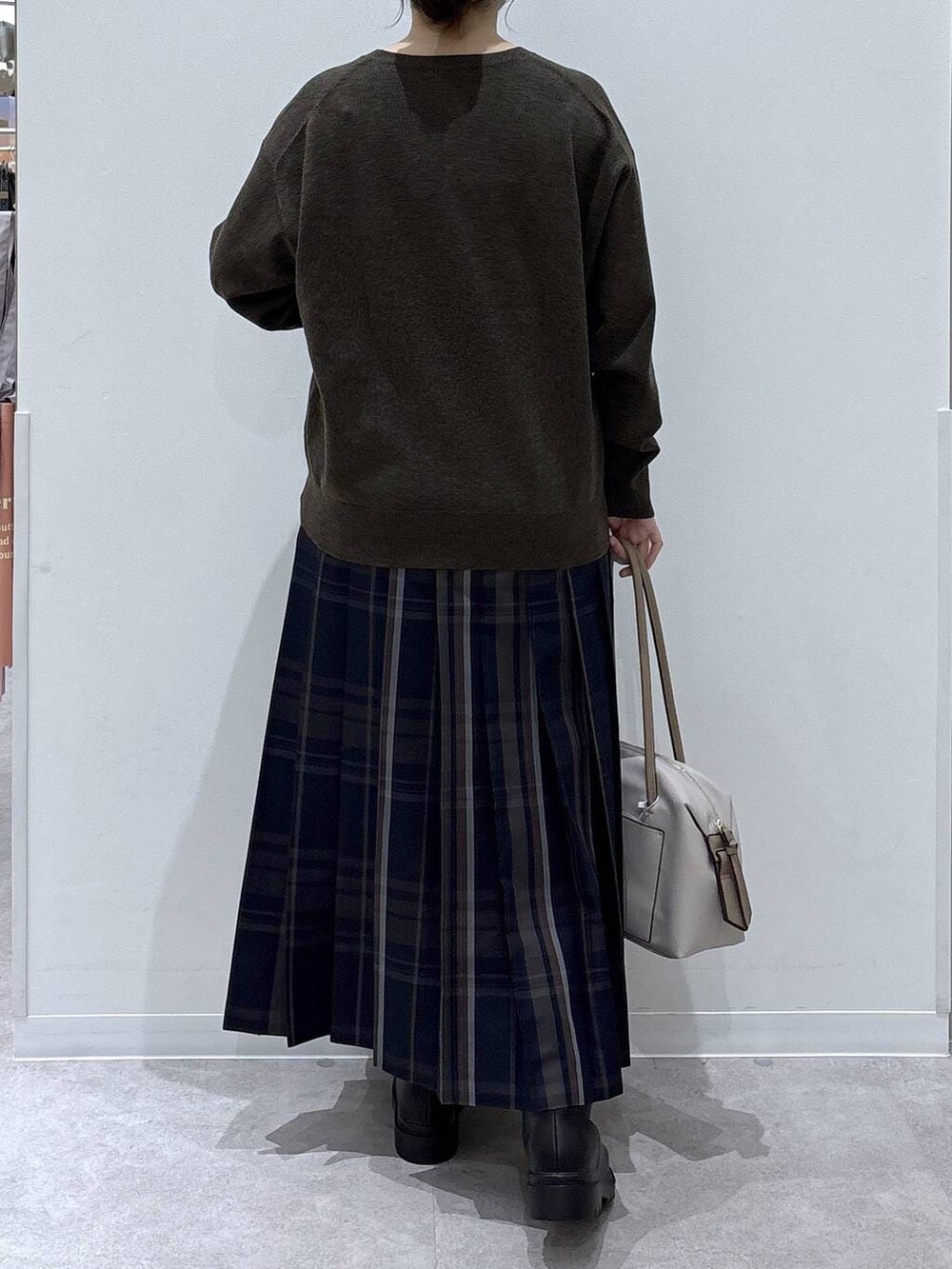 ホワイト系のボストンバッグ、ホワイト系のブルゾン、ブラック系のブーツを着用したレディースの冬コーディネートの6枚目の写真