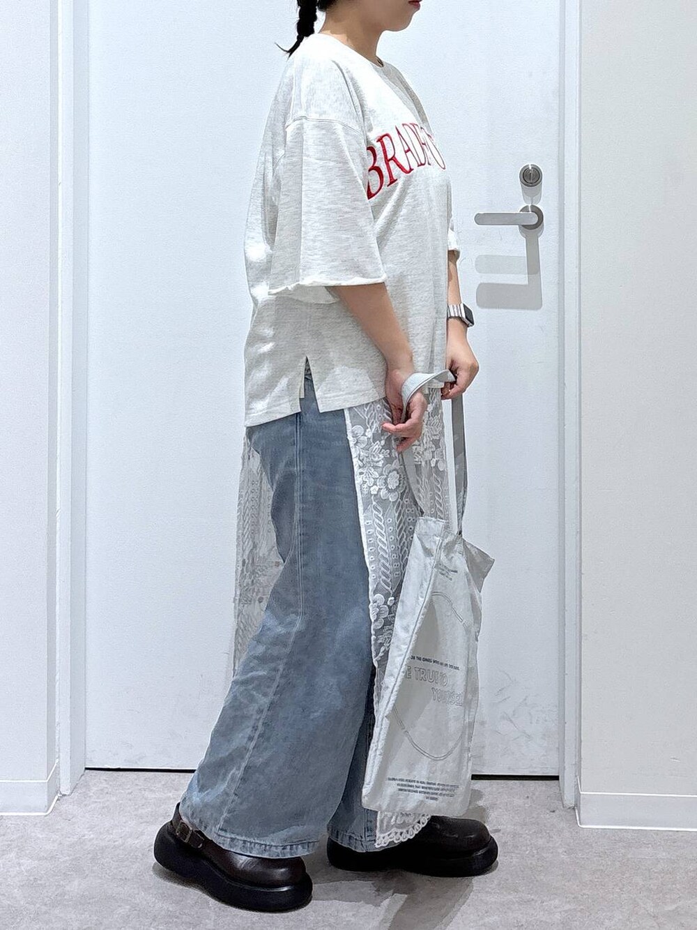 ブルー系のデニムパンツ、グレー系のトートバッグ、その他のストール/ショールを着用したレディースの秋コーディネートの2枚目の写真