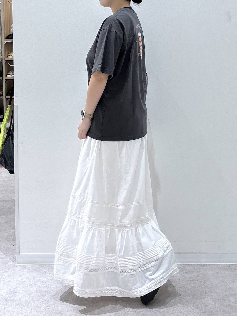 ホワイト系のスカート、パープル系のトートバッグ、グレー系のTシャツ/カットソーを着用したレディースの夏コーディネートの2枚目の写真
