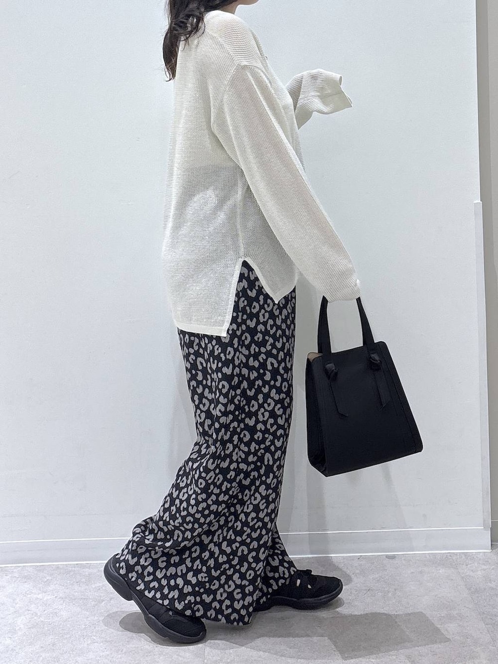 ブラック系のショルダーバッグ、その他のその他パンツ、ホワイト系のニット/セーターを着用したレディースの春コーディネートの2枚目の写真