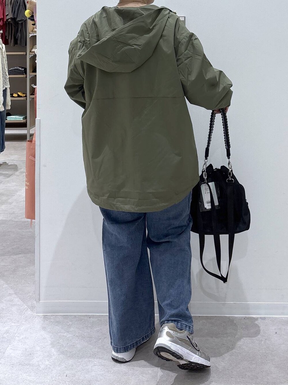 ブルー系のデニムパンツ、ホワイト系のTシャツ/カットソー、グリーン系のマウンテンパーカーを着用したレディースの秋コーディネートの3枚目の写真