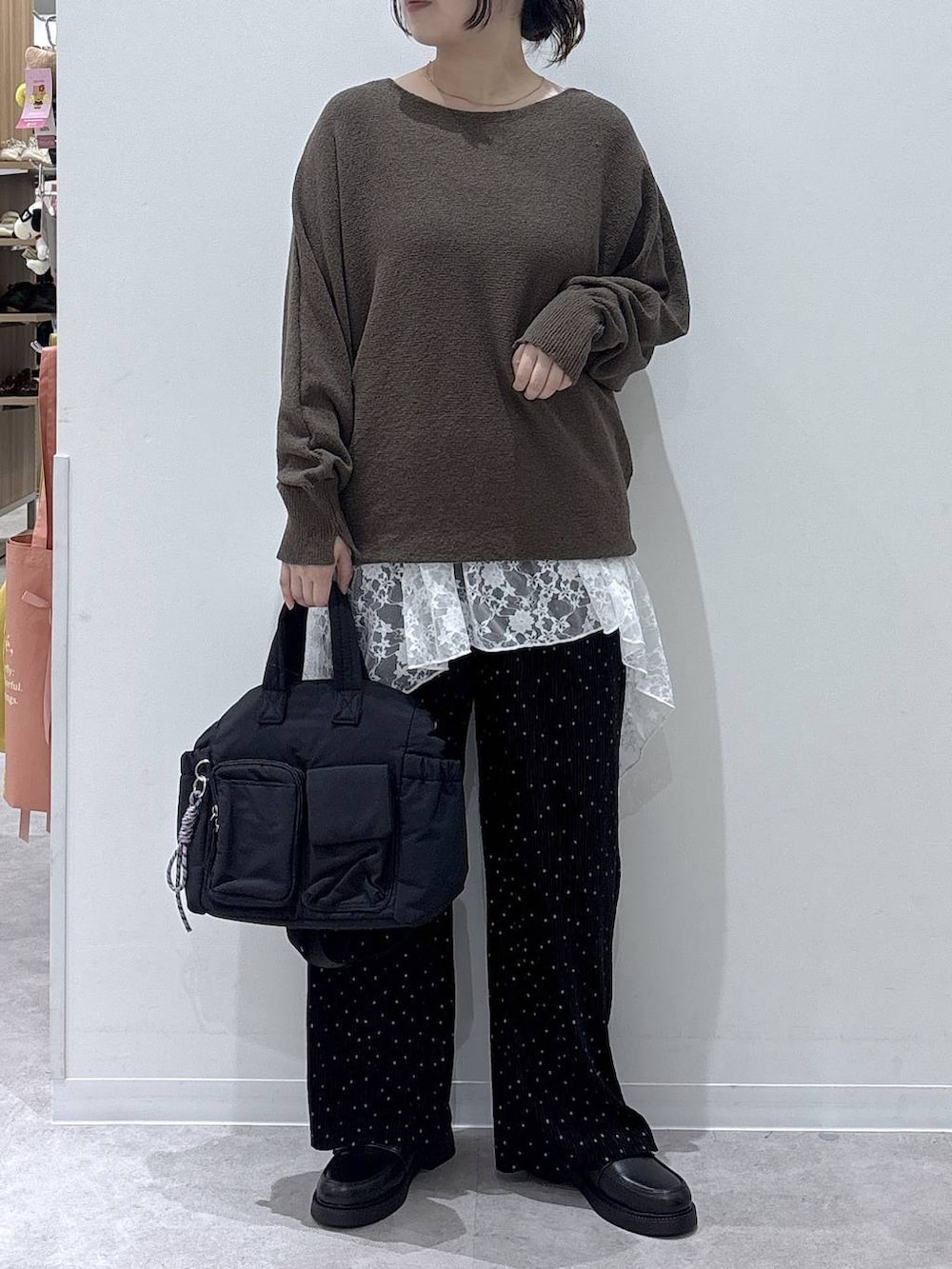 ブラック系のトートバッグ、ブラック系のその他パンツ、グリーン系のニット/セーターを着用したレディースの秋コーディネートの4枚目の写真