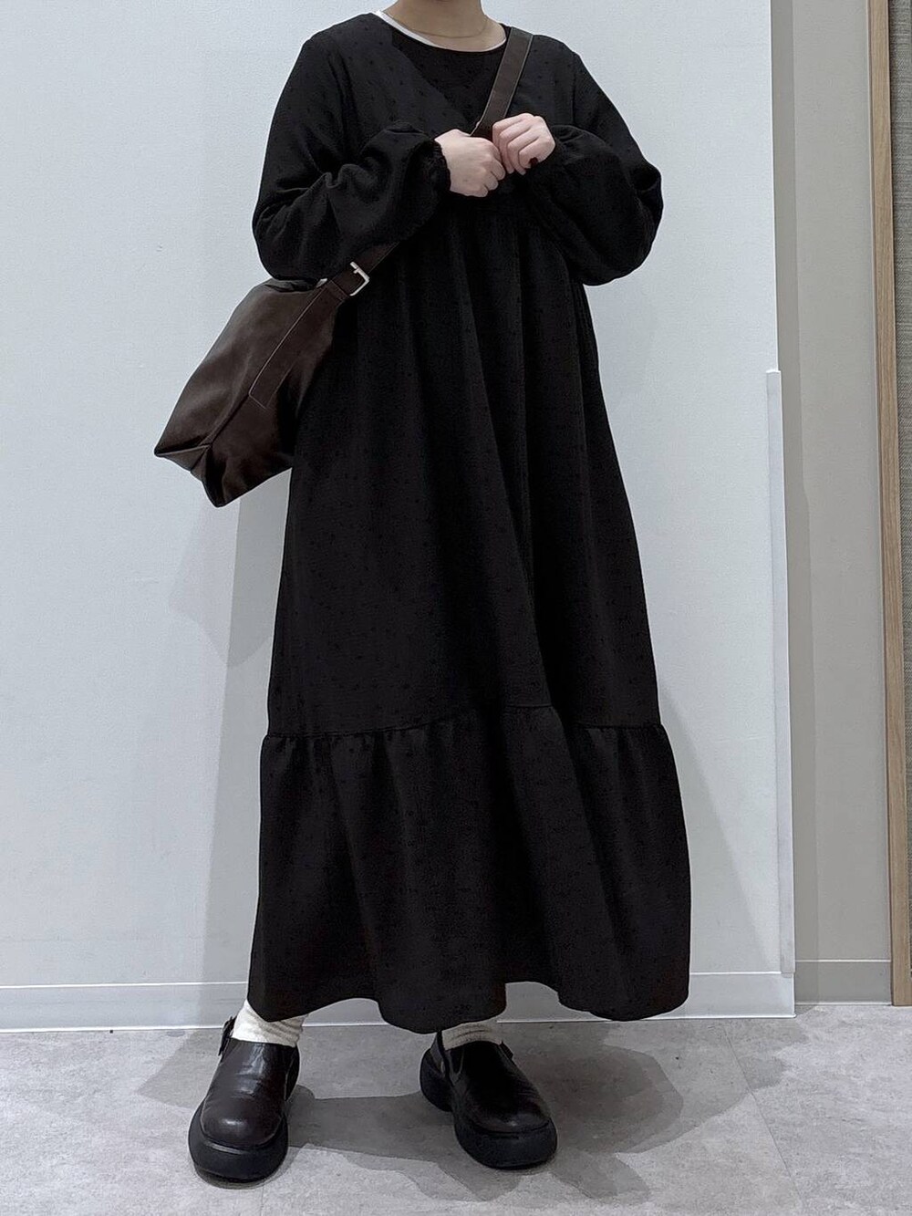 ブラウン系のショルダーバッグ、ブラウン系のワンピースを着用したレディースの冬コーディネートの4枚目の写真