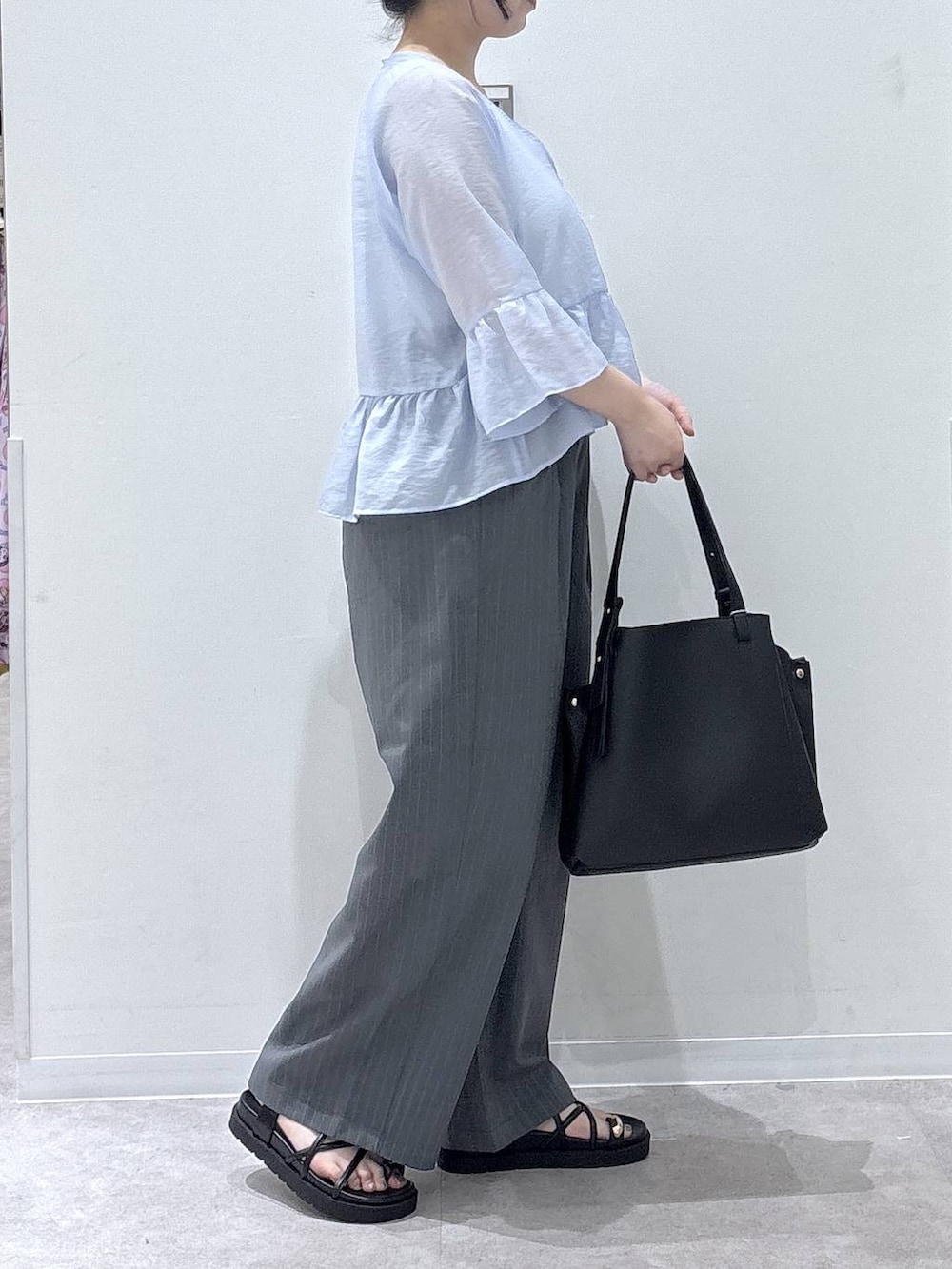 ブラック系のハンドバッグ、グレー系のその他パンツ、ブルー系のカーディガン/ボレロを着用したレディースの夏コーディネートの2枚目の写真
