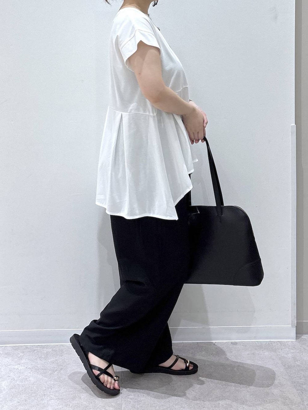 ブラック系のボストンバッグ、ブラック系のその他パンツ、ホワイト系のTシャツ/カットソーを着用したレディースの夏コーディネートの2枚目の写真