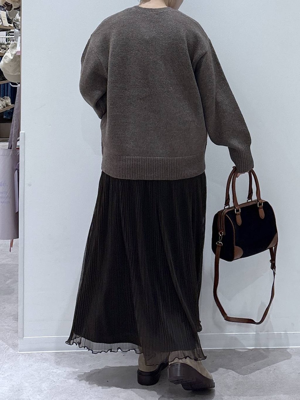 ブラウン系のダウンジャケット/コート、ベージュ系のブーツ、ブラック系のボストンバッグを着用したレディースの冬コーディネートの7枚目の写真