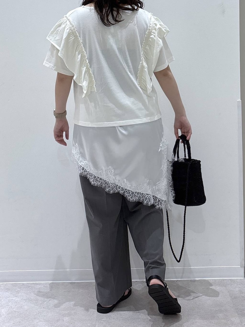 グレー系のその他パンツ、ブラック系のクラッチバッグ、ベージュ系のTシャツ/カットソーを着用したレディースの夏コーディネートの2枚目の写真