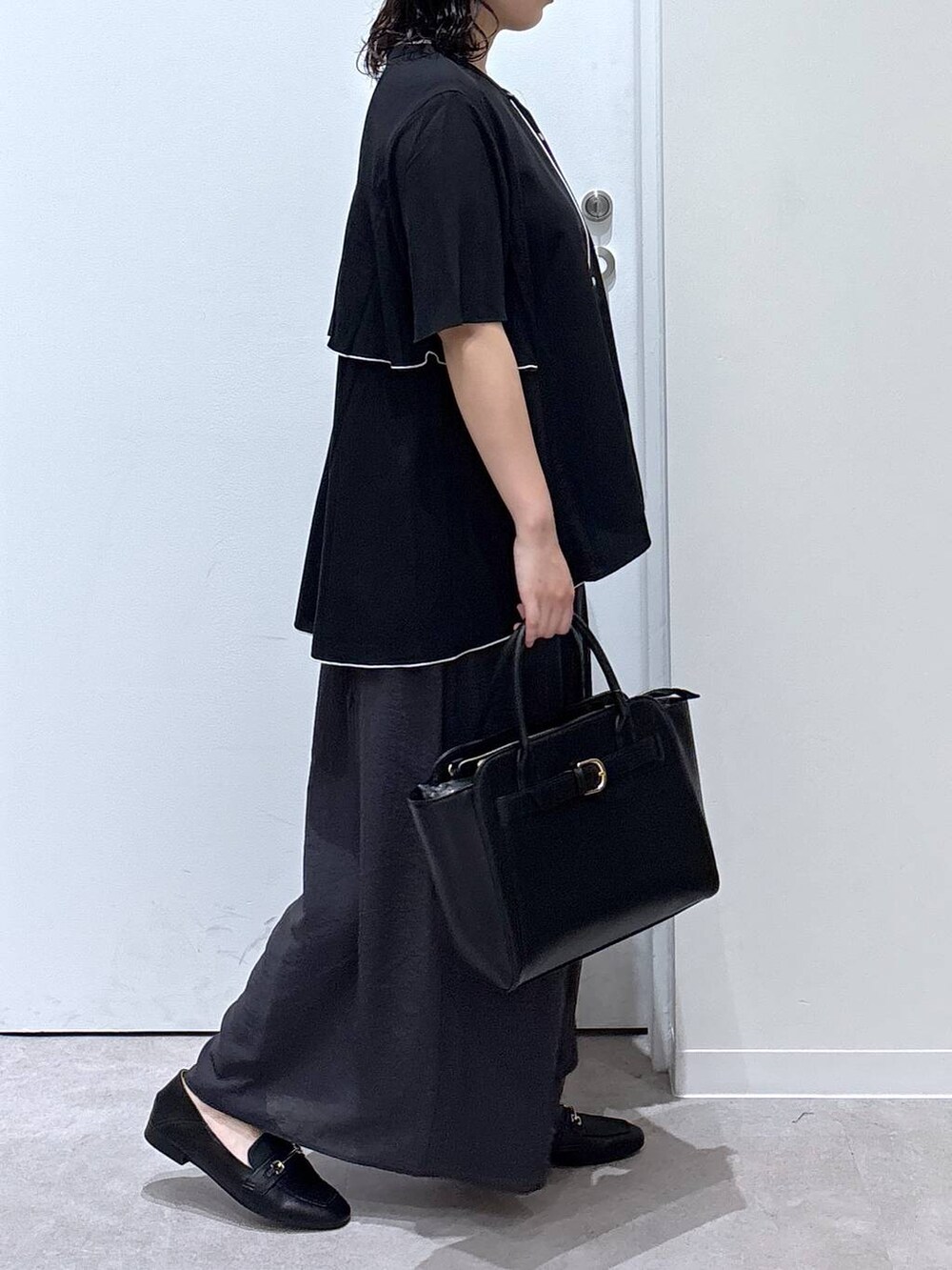 ブラック系のローファー、ブラック系のショルダーバッグ、ブラック系のシャツ/ブラウスを着用したレディースの夏コーディネートの2枚目の写真