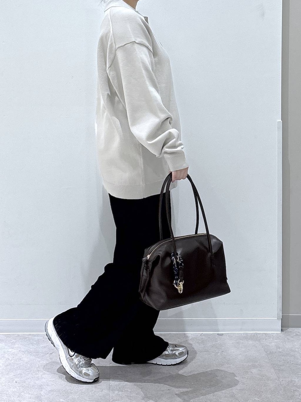 ブラック系のその他パンツ、ブラウン系のボストンバッグ、ベージュ系のカーディガン/ボレロを着用したレディースの秋コーディネートの2枚目の写真