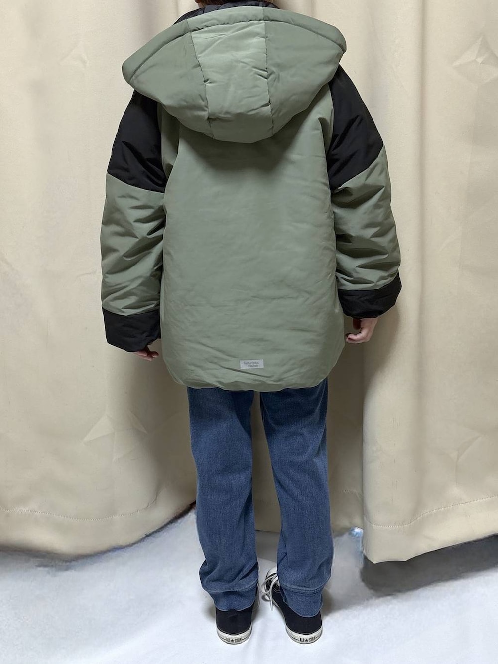 グリーン系のブルゾン、ブルー系のデニムパンツを着用したキッズの冬コーディネートの3枚目の写真