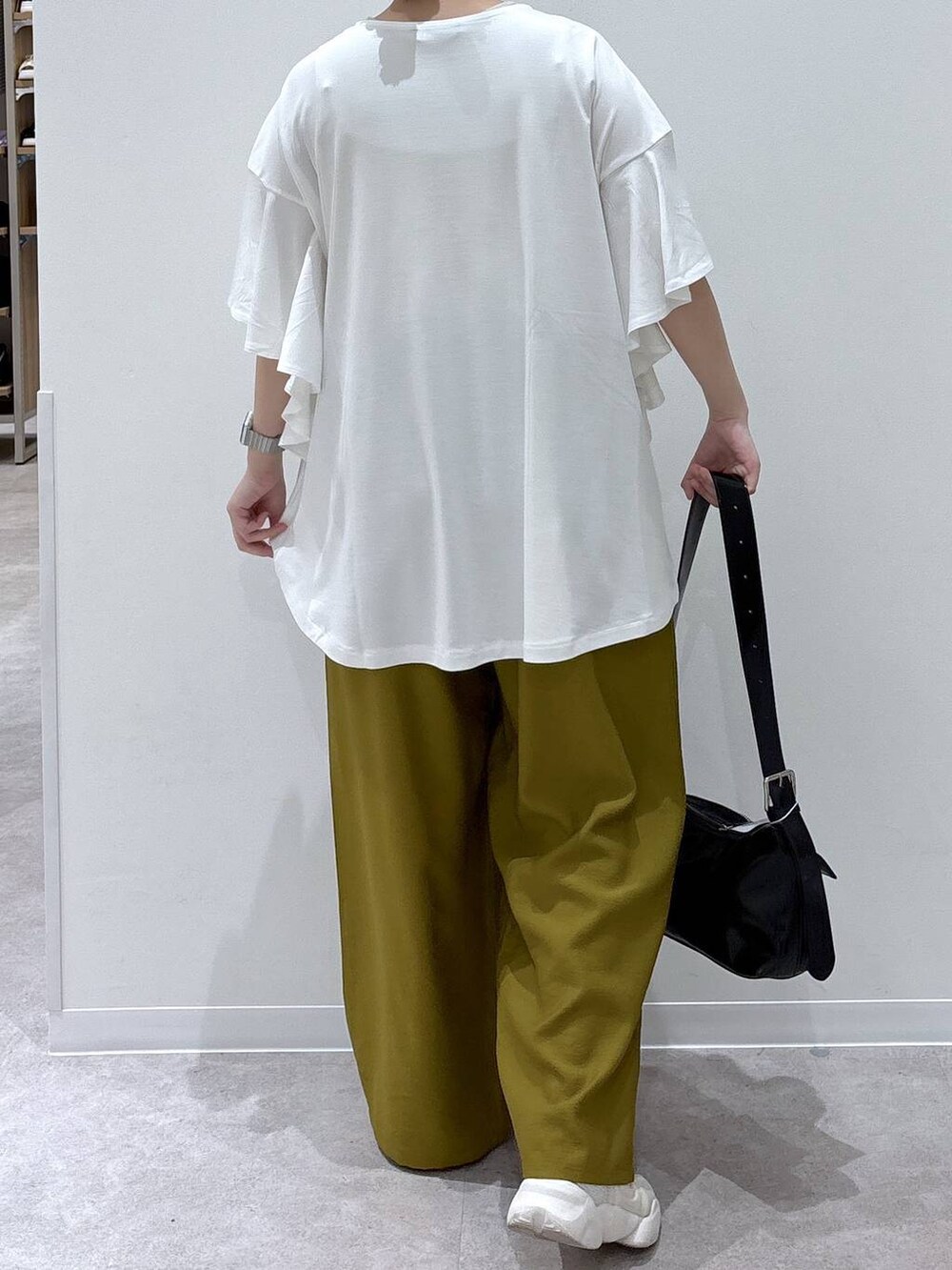 ブラック系のショルダーバッグ、ホワイト系のTシャツ/カットソーを着用したレディースの春コーディネートの3枚目の写真